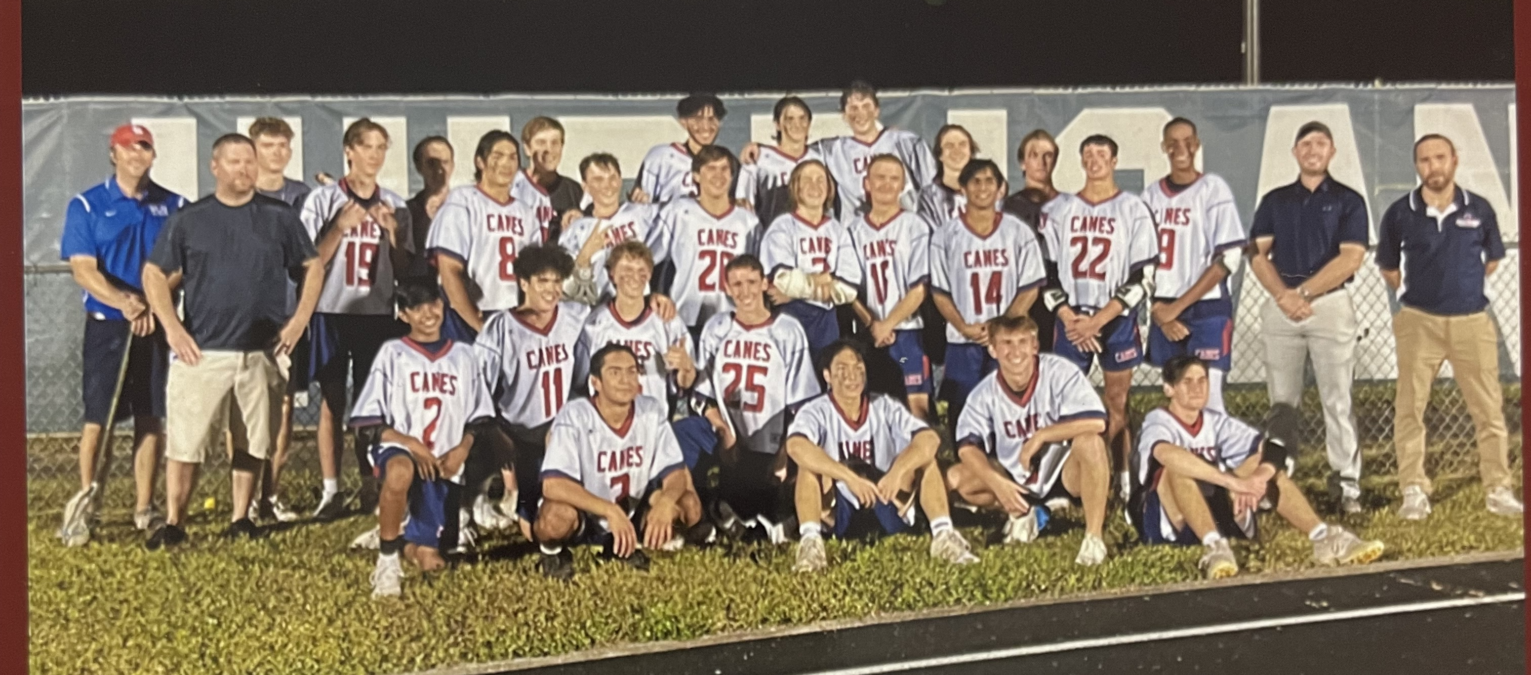 A group of people in sports uniforms posing for a photoDescription automatically generated